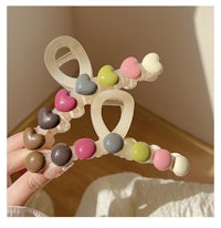 a person holding a pair of heart shaped clothes hangers