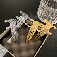 three gold and silver hair clips in a box